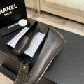 Chanel square-toe leather loafers in dark olive with gold CC logo medallion, shown with original Chanel Paris box and camellia ribbon